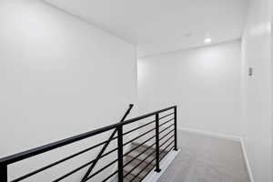 Stairway with carpet floors and recessed lighting
