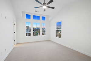 Unfurnished room with high vaulted ceiling, light carpet, and ceiling fan