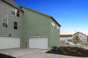 View of home's exterior featuring stucco siding, an attached garage, and concrete driveway