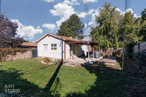 Rear view of house with a fenced backyard, a patio, and a jacuzzi