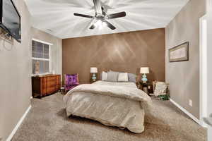 Carpeted bedroom featuring ceiling fan and baseboards