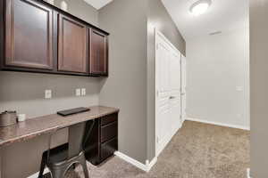 Office space with light colored carpet and built in desk