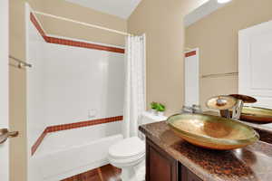 Full bathroom with shower / bathtub combination with curtain, vanity, and wood finished floors
