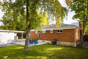 Rear view of property featuring a patio, brick siding, and a chimney