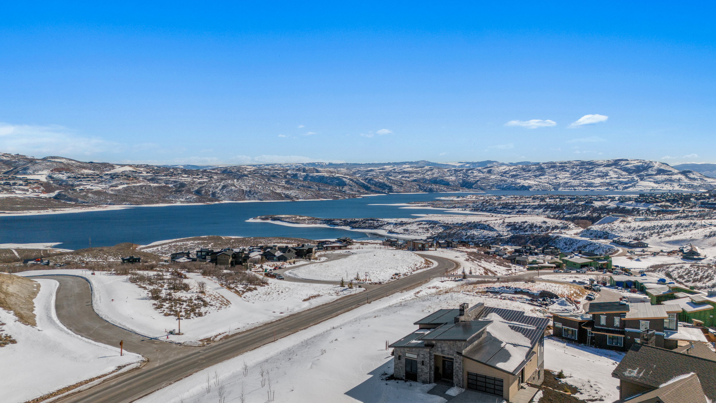 Snowy aerial view featuring a water and mountain view