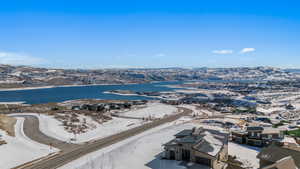 Snowy aerial view featuring a water and mountain view
