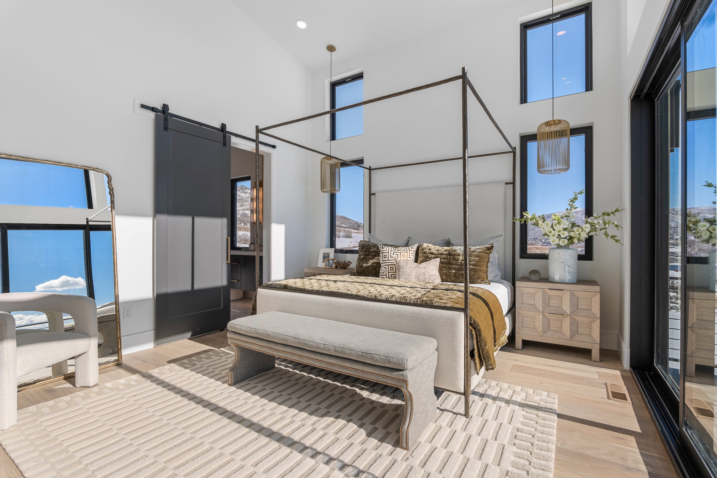 Bedroom featuring a barn door, a high ceiling, light wood-type flooring, and recessed lighting