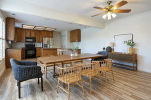 Dining space with ornamental molding, light wood-style flooring, and ceiling fan