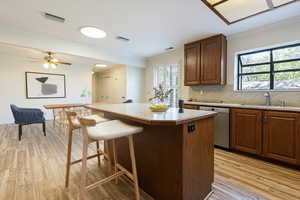 Kitchen with crown molding, a kitchen bar, tasteful backsplash, a center island, and light countertops