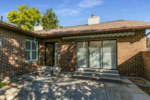 Back of property with a chimney and brick siding