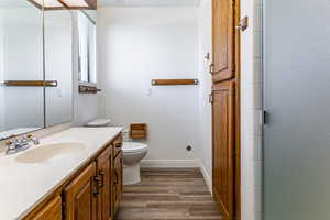 Full bathroom featuring vanity, dark wood-type flooring, and an enclosed shower