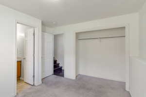 Unfurnished bedroom with light carpet and a closet