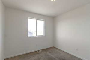 Carpeted empty room featuring baseboards