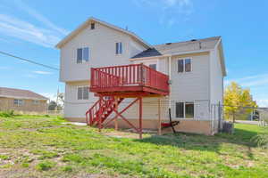 Back of property featuring a fenced backyard, a deck, and stairs