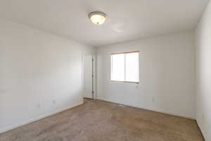 Carpeted empty room featuring baseboards