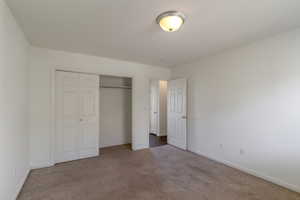Unfurnished bedroom featuring carpet and a closet