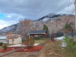 View of yard featuring a mountain view, a carport, and a storage unit