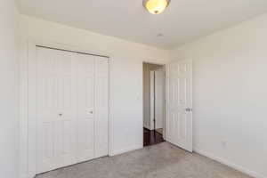 Unfurnished bedroom with carpet flooring and a closet