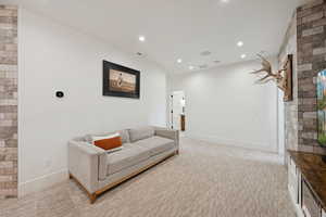 Sitting room with light colored carpet and recessed lighting