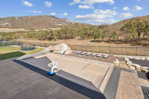 View of pool with a mountain view, a trampoline, a fenced backyard, and a water slide