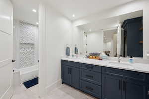 Bathroom featuring double vanity, light tile patterned floors, shower / bath combination, and recessed lighting