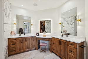 Bathroom with two vanities, recessed lighting, and a marble finish shower