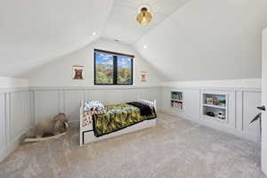 Bedroom with a decorative wall, vaulted ceiling, light colored carpet, and recessed lighting