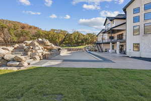 View of community with stairway, a patio, a balcony, and a lawn