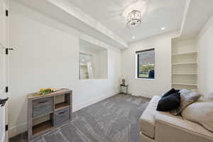 Living area with carpet flooring, recessed lighting, a chandelier, and built in shelves