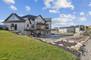Back of house with a yard, a patio area, and board and batten siding