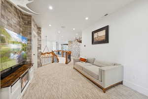 Sitting room featuring an upstairs landing, light carpet, and recessed lighting