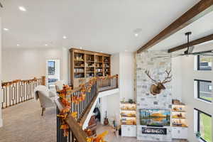 Bar with a stone fireplace, recessed lighting, wood finished floors, and beam ceiling