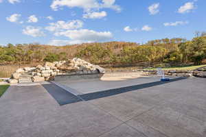 View of pool with a water slide and a wooded view