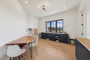 Office with light wood-style floors and recessed lighting