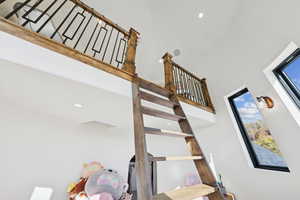 Stairs featuring recessed lighting and a towering ceiling