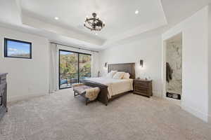 Bedroom featuring a raised ceiling, light carpet, access to exterior, and recessed lighting