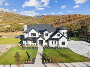 Modern inspired farmhouse featuring a standing seam roof, a metal roof, board and batten siding, and a chimney