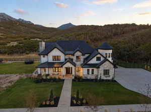 Modern farmhouse style home featuring board and batten siding, stone siding, a metal roof, a standing seam roof, and a chimney