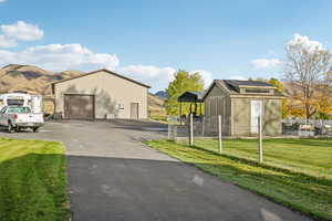 View of front of home with an outbuilding, a detached garage, mountain and rural views, and a metal roof