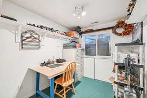 Office space featuring carpet floors and a workshop area