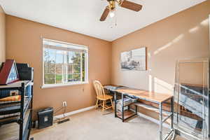 Office area with light colored carpet, ceiling fan, and a textured ceiling