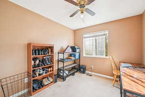 Home office featuring light carpet and ceiling fan