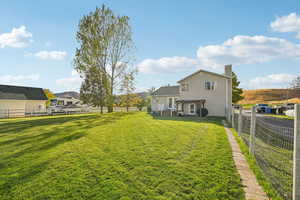 Rear view of house with a fenced backyard, a chimney, and a mountain view