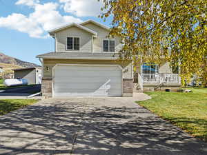 Traditional-style house with brick siding, concrete driveway, a garage, and a front yard