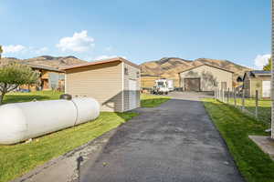View of side of property with mountain and rural views, an outdoor structure, and a garage