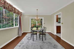 Dining space featuring plenty of natural light, dark wood finished floors, and crown molding