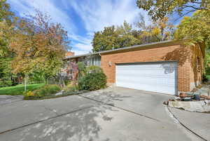 Ranch-style house with driveway, brick siding, and an attached garage