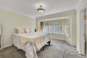 Carpeted bedroom featuring ornamental molding