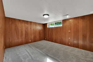 Below grade area with carpet floors and wooden walls