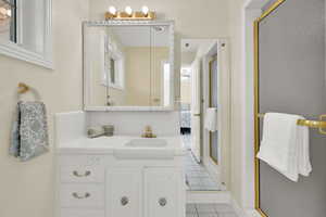 Full bath with light tile patterned floors, a shower stall, ensuite bath, and vanity